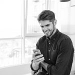 A man smiling at his phone