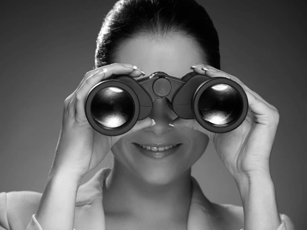 lady searching with binoculars black and white photo